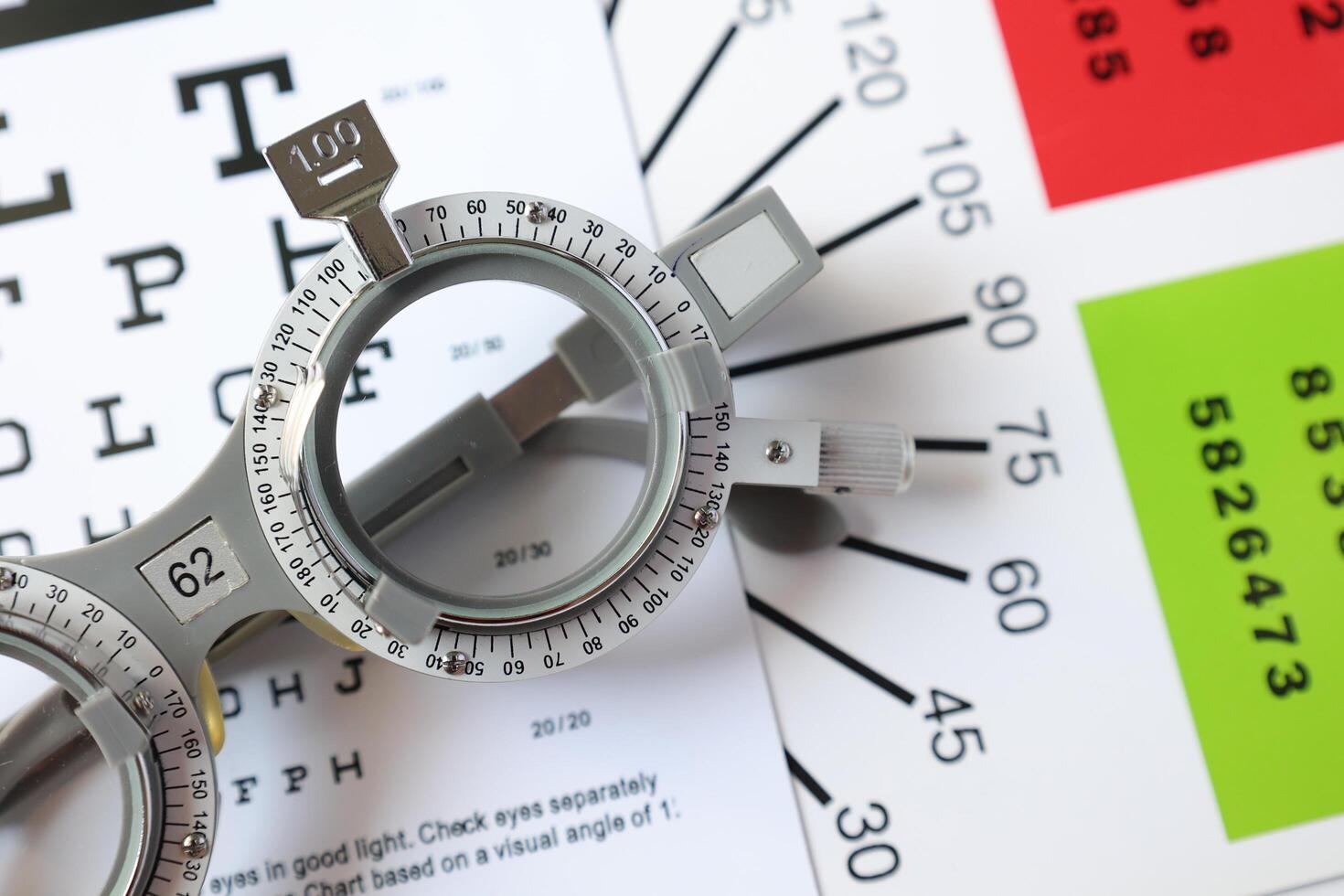 Trial frame glasses for eye test on chart in optical store photo