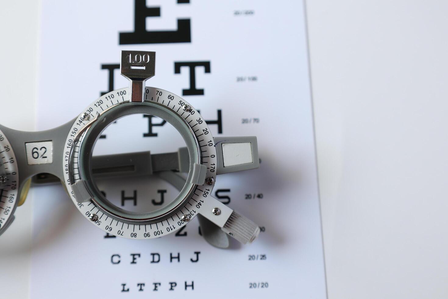 Trial frame glasses for eye test on chart in optical store photo