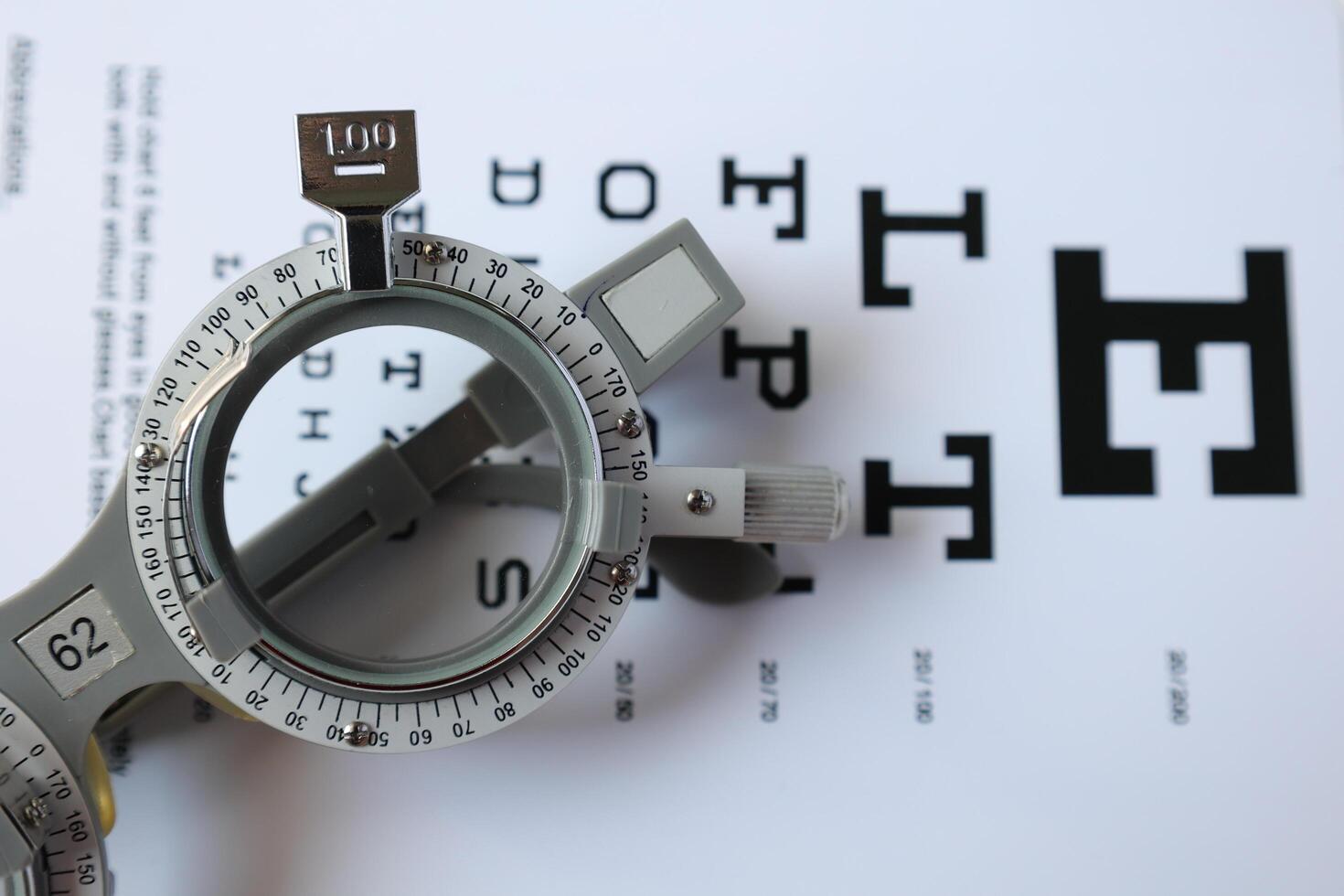 Trial frame glasses for eye test on chart in optical store photo