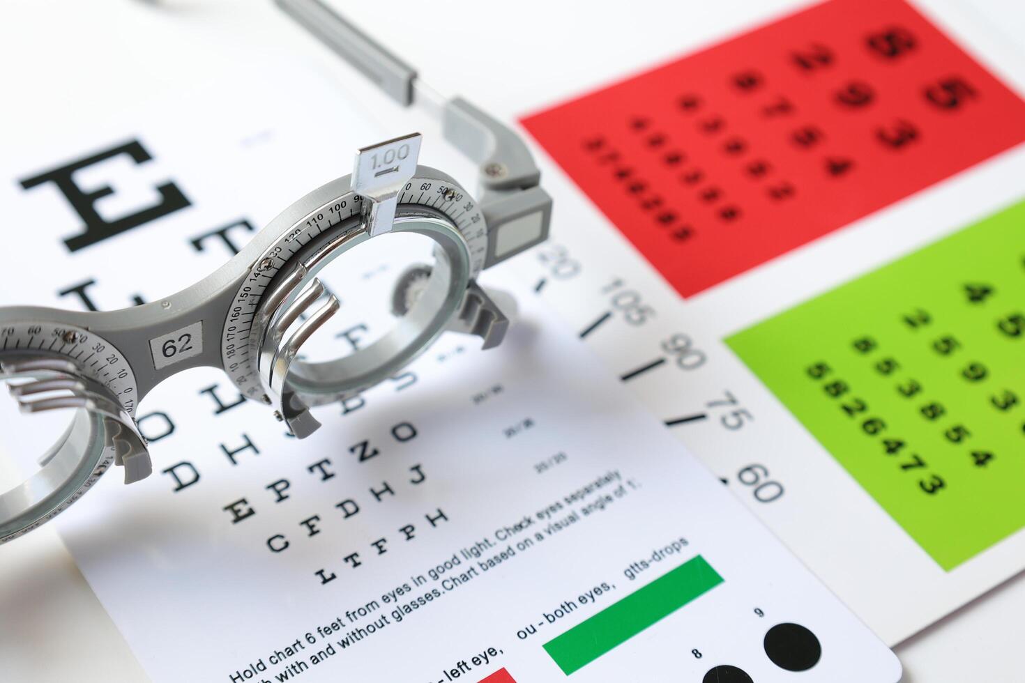 Trial frame glasses for eye test on chart in optical store photo