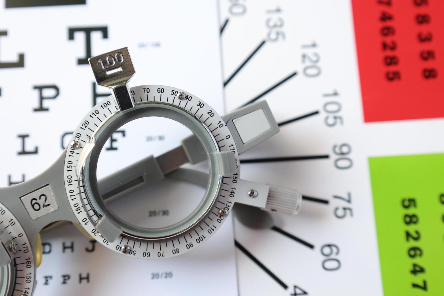 Trial frame glasses for eye test on chart in optical store photo