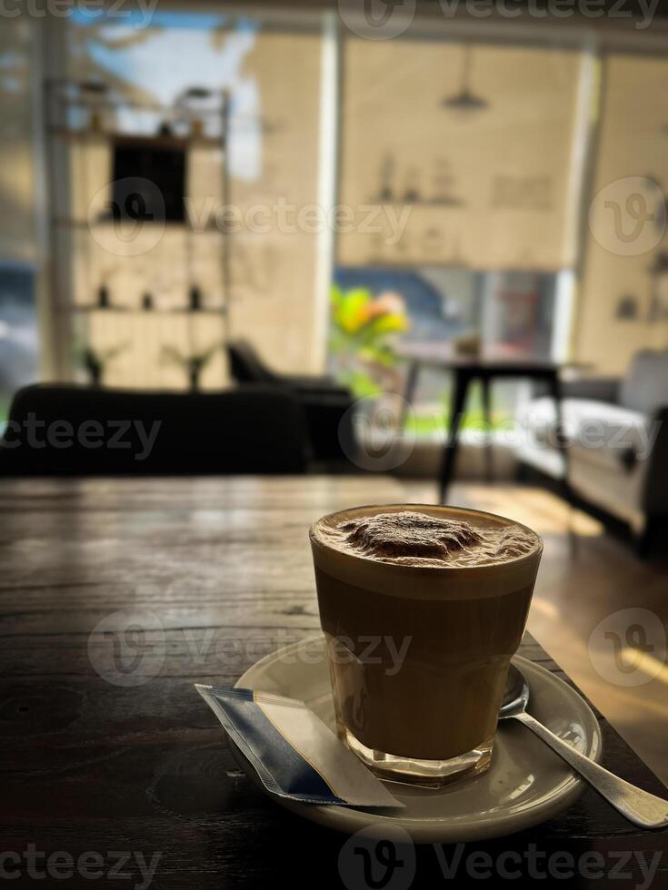 Glass of coffee latte cappuccino on the wooden table. photo