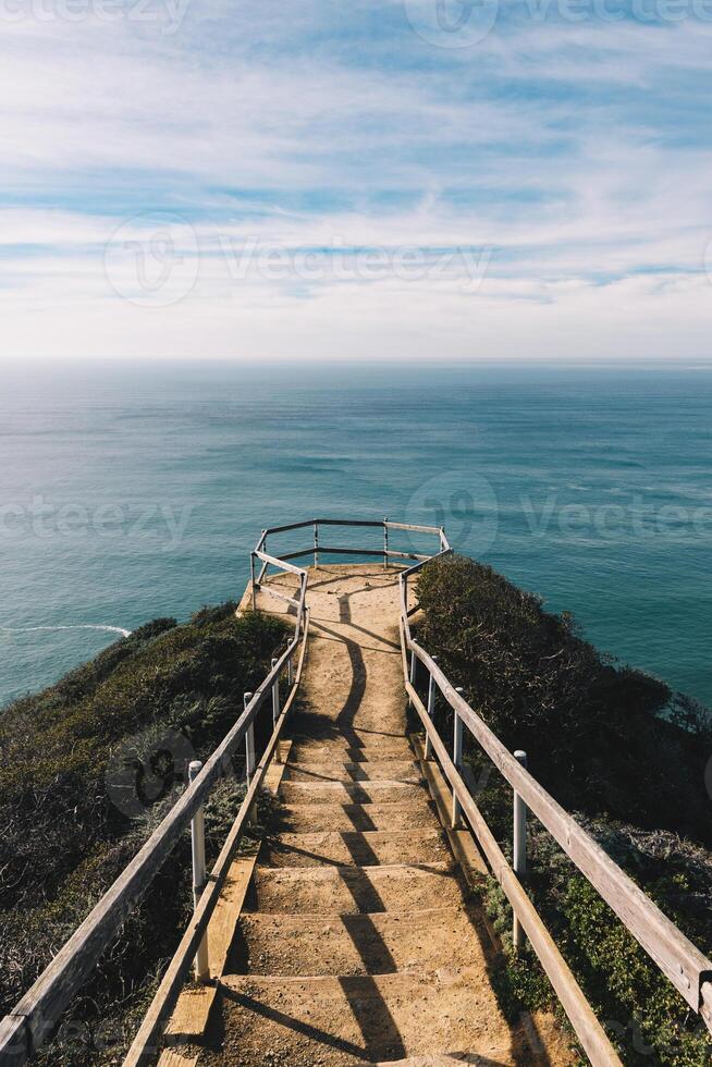 Stairs above the ocean with a blue sky on the background photo
