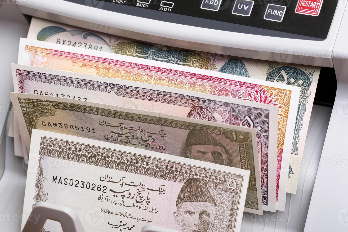Old Pakistani rupee in a counting machine photo