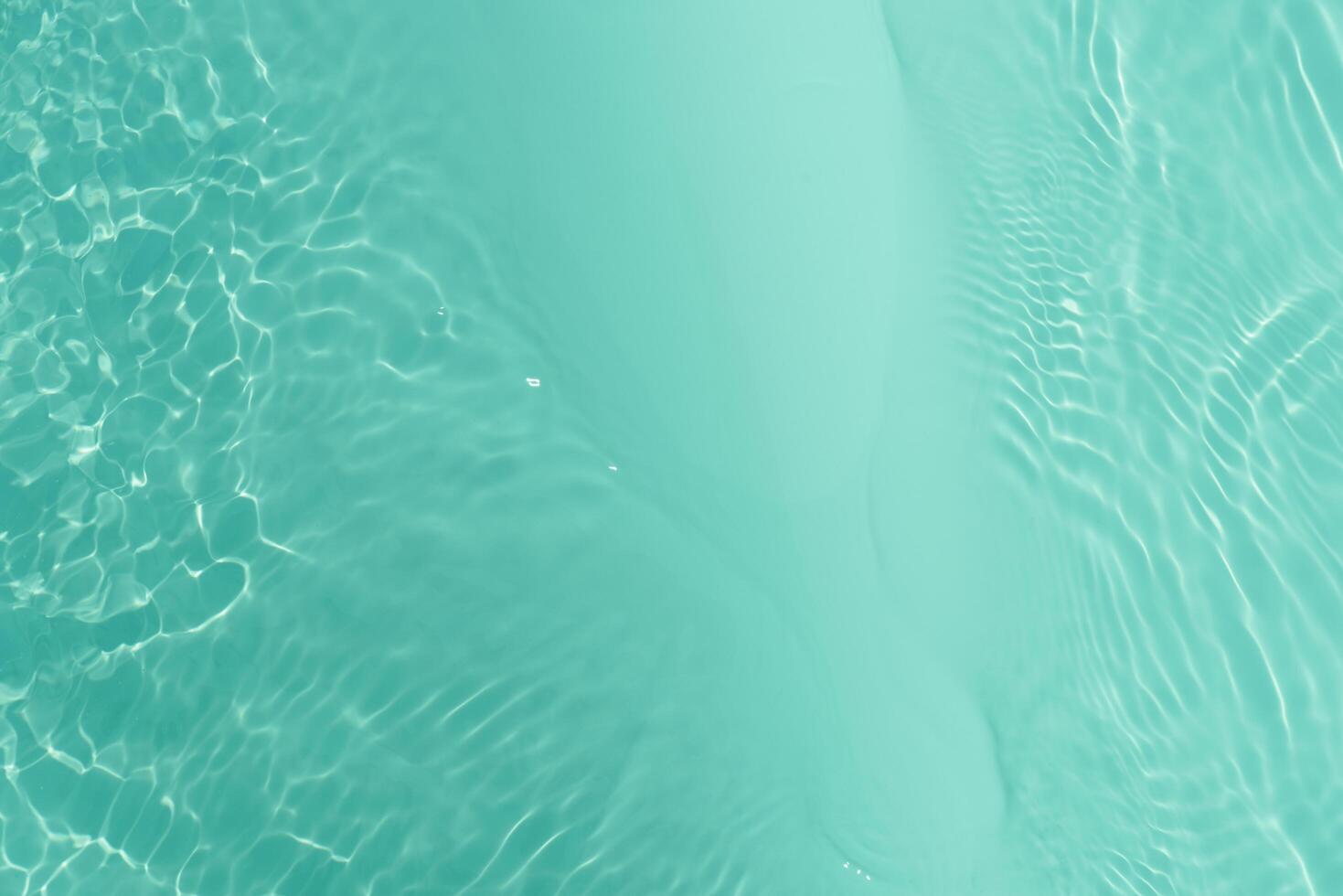 Blue water with ripples on the surface. Defocus blurred transparent blue colored clear calm water surface texture with splashes and bubbles. Water waves with shining pattern texture background. photo