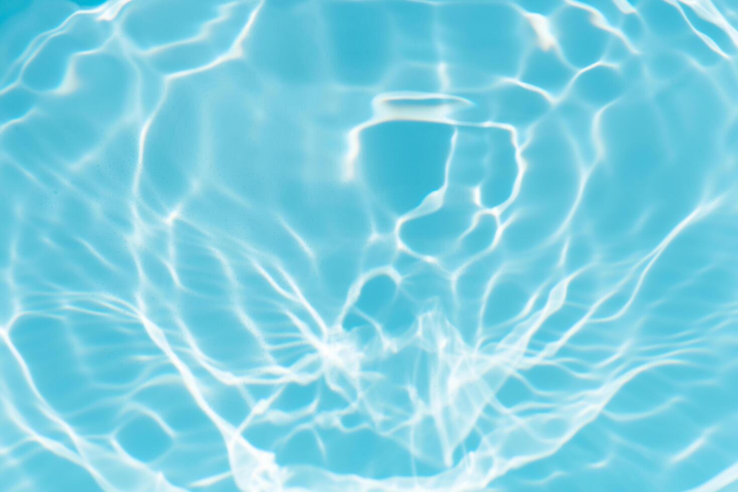 Bluewater waves on the surface ripples blurred. Defocus blurred transparent blue colored clear calm water surface texture with splash and bubbles. Water waves with shining pattern texture background. photo