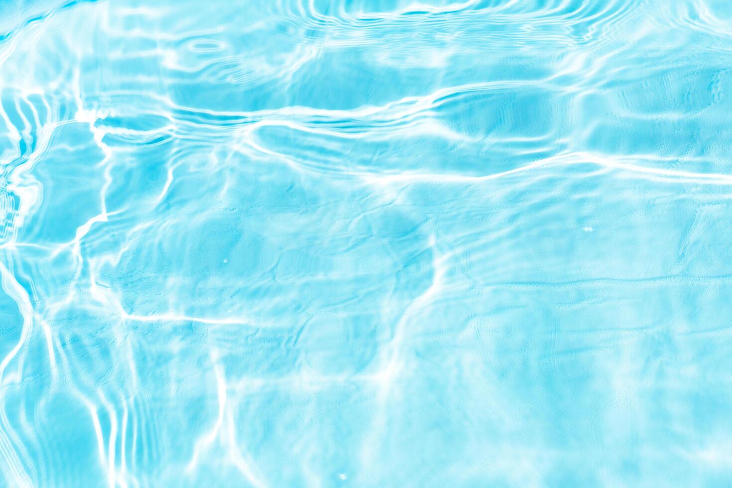 Bluewater waves on the surface ripples blurred. Defocus blurred transparent blue colored clear calm water surface texture with splash and bubbles. Water waves with shining pattern texture background. photo