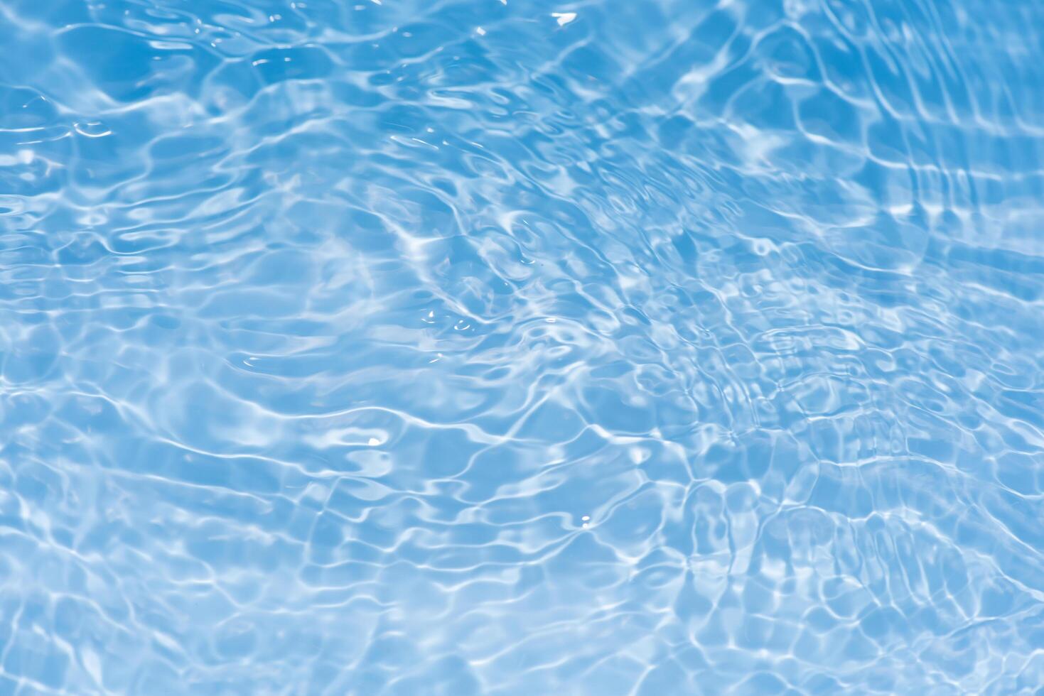 Bluewater waves on the surface ripples blurred. Defocus blurred transparent blue colored clear calm water surface texture with splash and bubbles. Water waves with shining pattern texture background. photo