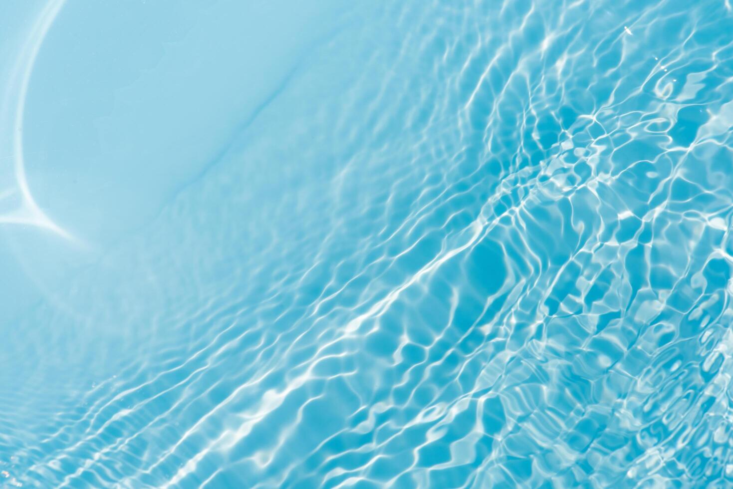 Bluewater waves on the surface ripples blurred. Defocus blurred transparent blue colored clear calm water surface texture with splash and bubbles. Water waves with shining pattern texture background. photo