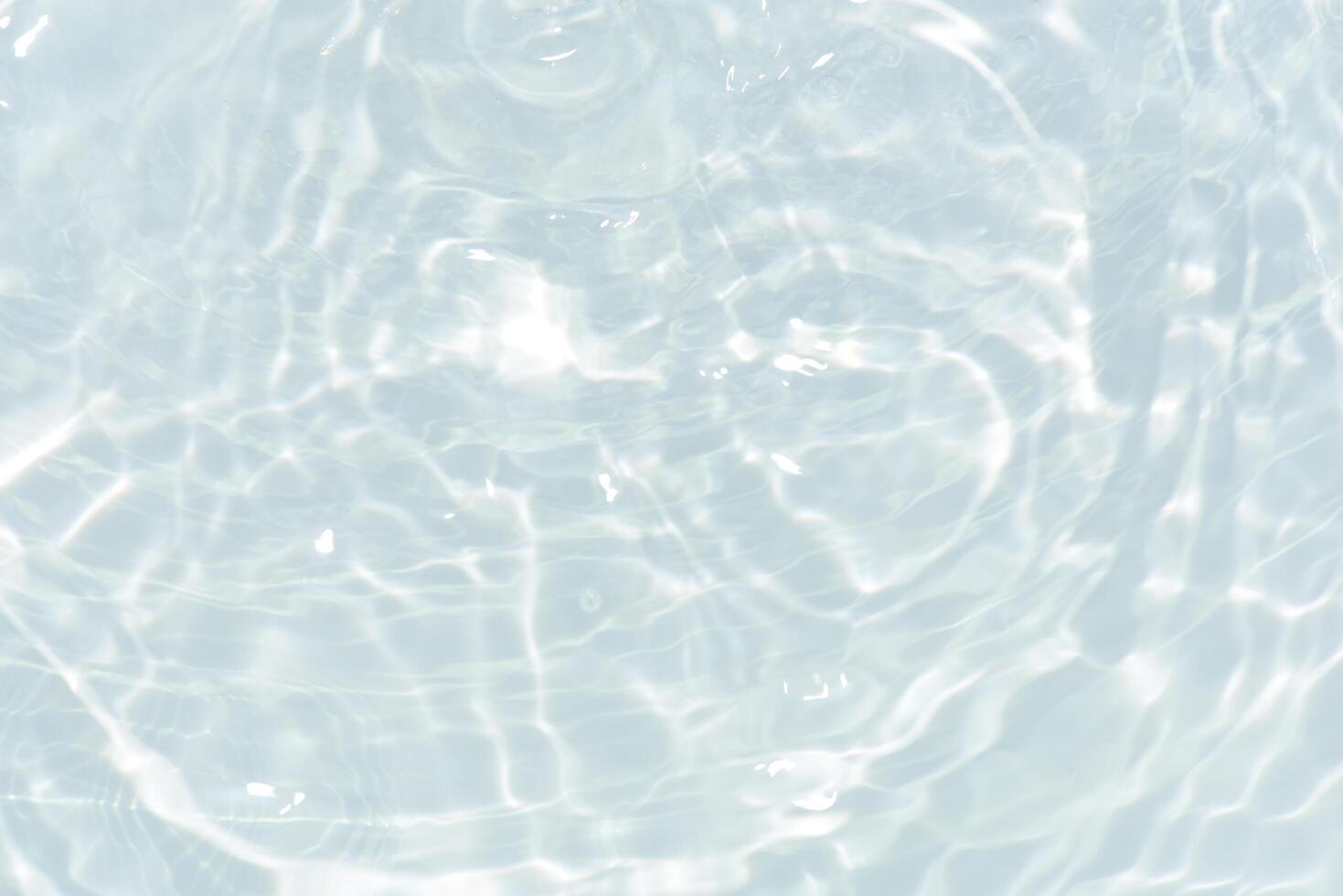 Blue water with ripples on the surface. Defocus blurred transparent blue colored clear calm water surface texture with splashes and bubbles. Water waves with shining pattern texture background. photo