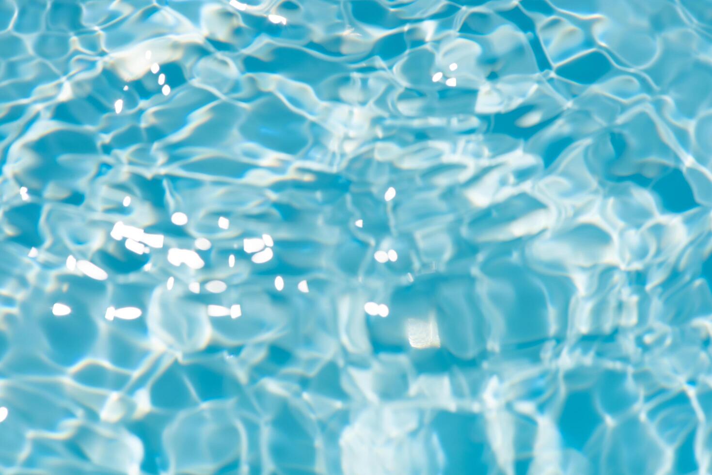 Blue water with ripples on the surface. Defocus blurred transparent blue colored clear calm water surface texture with splashes and bubbles. Water waves with shining pattern texture background. photo