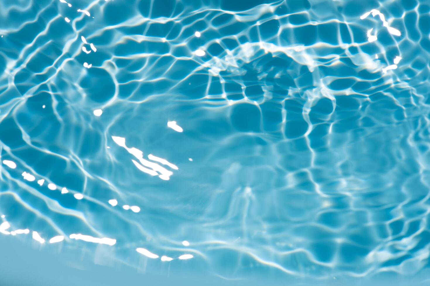 Blue water with ripples on the surface. Defocus blurred transparent blue colored clear calm water surface texture with splashes and bubbles. Water waves with shining pattern texture background. photo