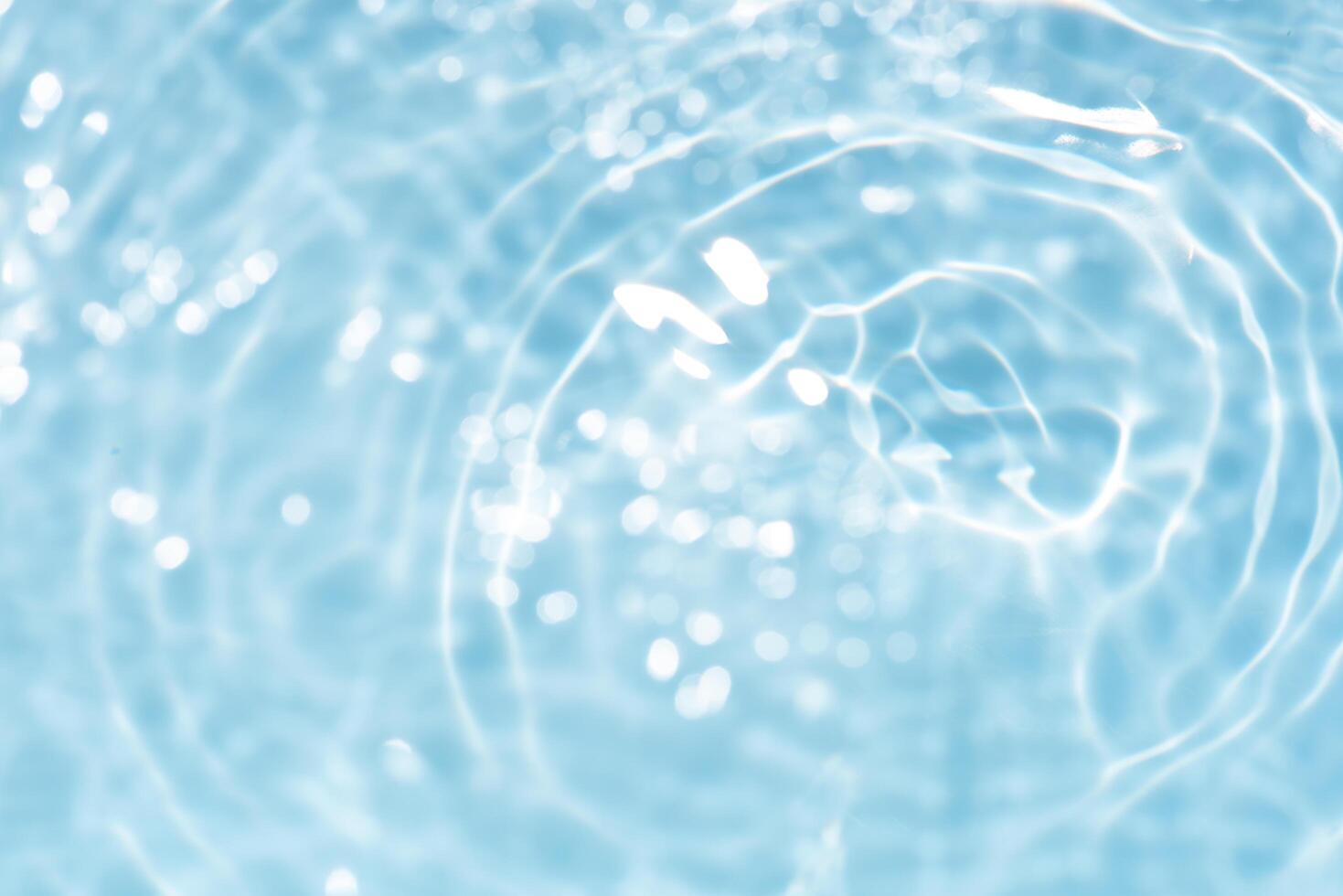 Blue water with ripples on the surface. Defocus blurred transparent blue colored clear calm water surface texture with splashes and bubbles. Water waves with shining pattern texture background. photo