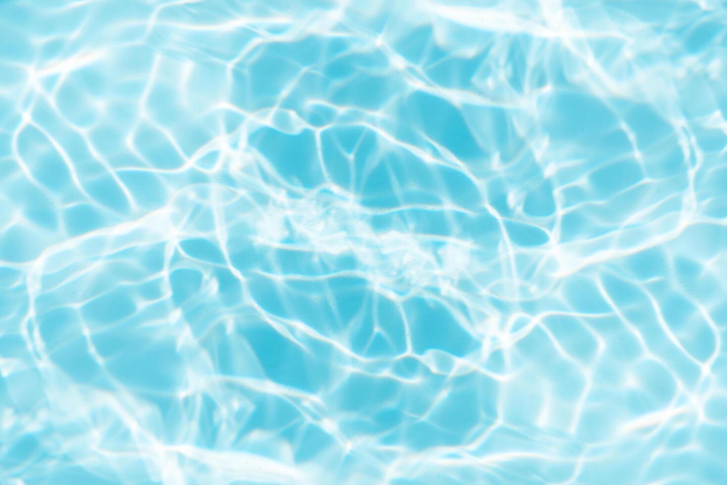 Bluewater waves on the surface ripples blurred. Defocus blurred transparent blue colored clear calm water surface texture with splash and bubbles. Water waves with shining pattern texture background. photo