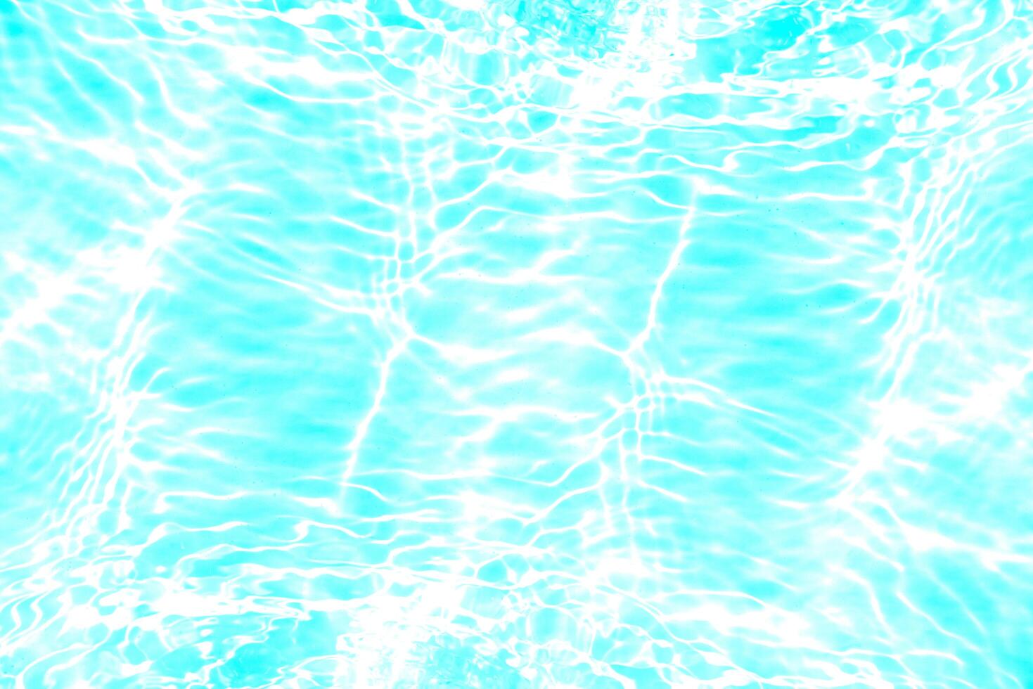 Blue water with ripples on the surface. Defocus blurred transparent blue colored clear calm water surface texture with splashes and bubbles. Water waves with shining pattern texture background. photo