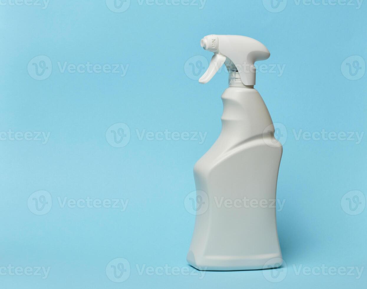White plastic bottle with spray on a blue background, container for household chemicals photo