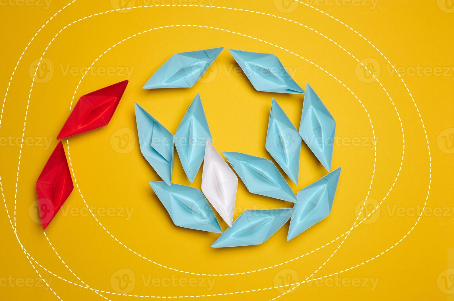 A group of colorful paper boats clustered on a yellow background photo