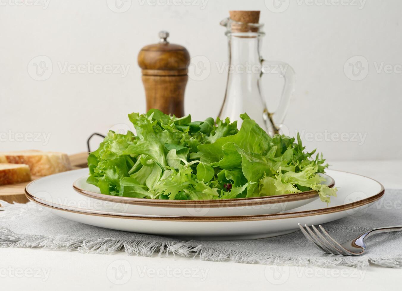 Fresh green lettuce leaves in a white plate on the table, healthy food photo