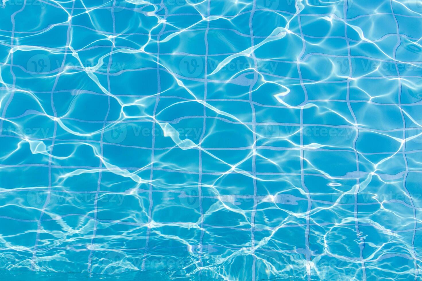Blue swimming pool water surface and ripple wave background. Summer abstract reflection caustics in swimming pool. photo