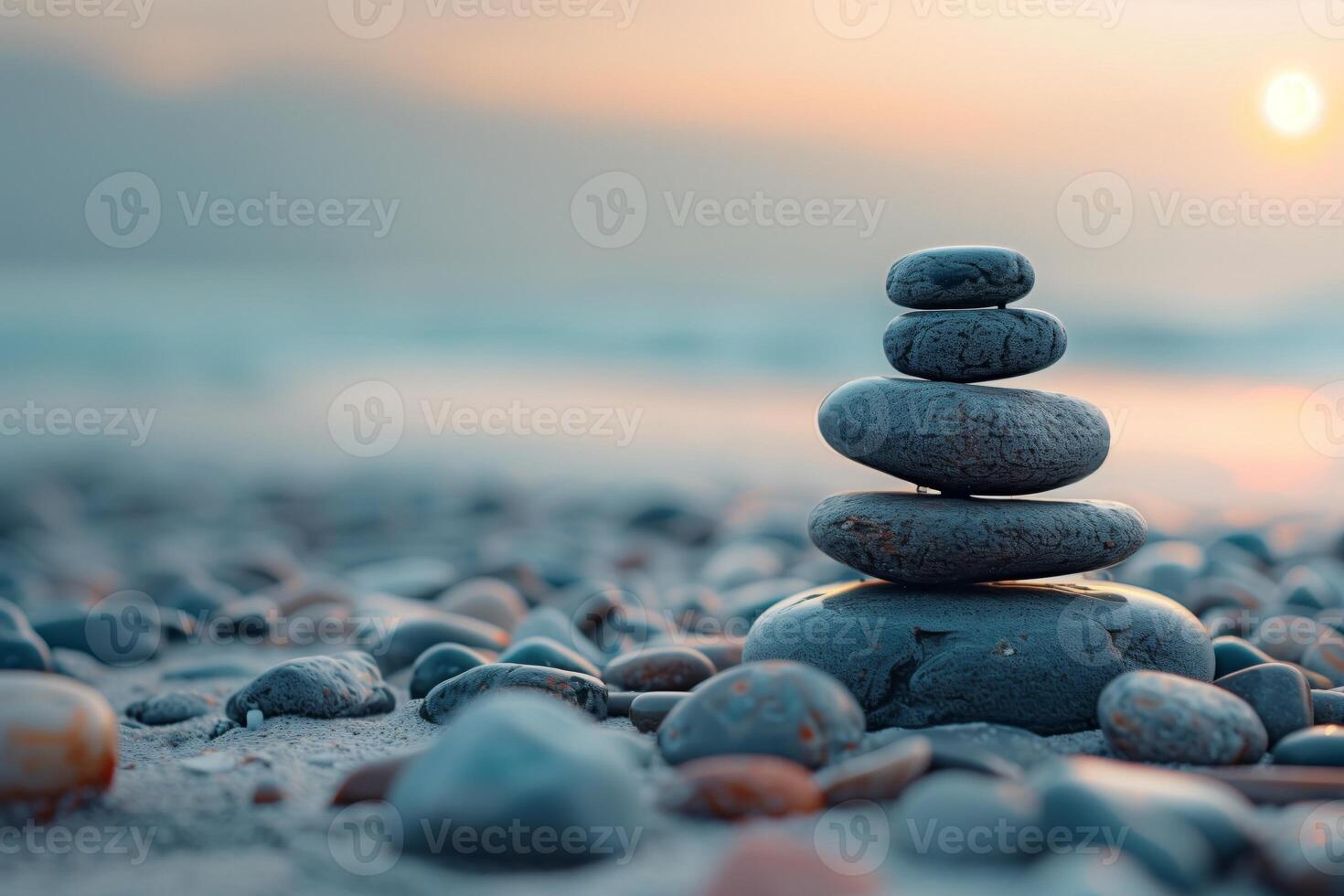 Stacked smooth pebbles on a serene beach at sunrise, embodying the essence of balance and meditation photo