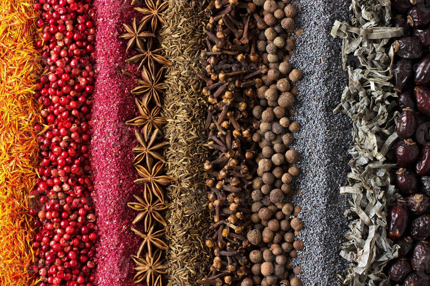 Various spices and herbs are scattered on table. Seasoning background for packaging with food. photo
