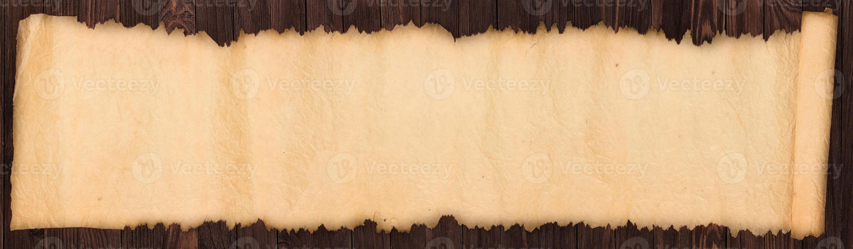 Old scroll on a wooden table, crumpled paper texture as background photo