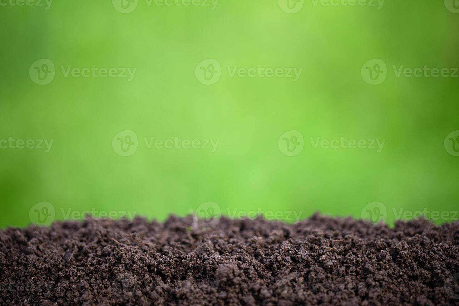 fertile pile of soil with green grass blurred background photo