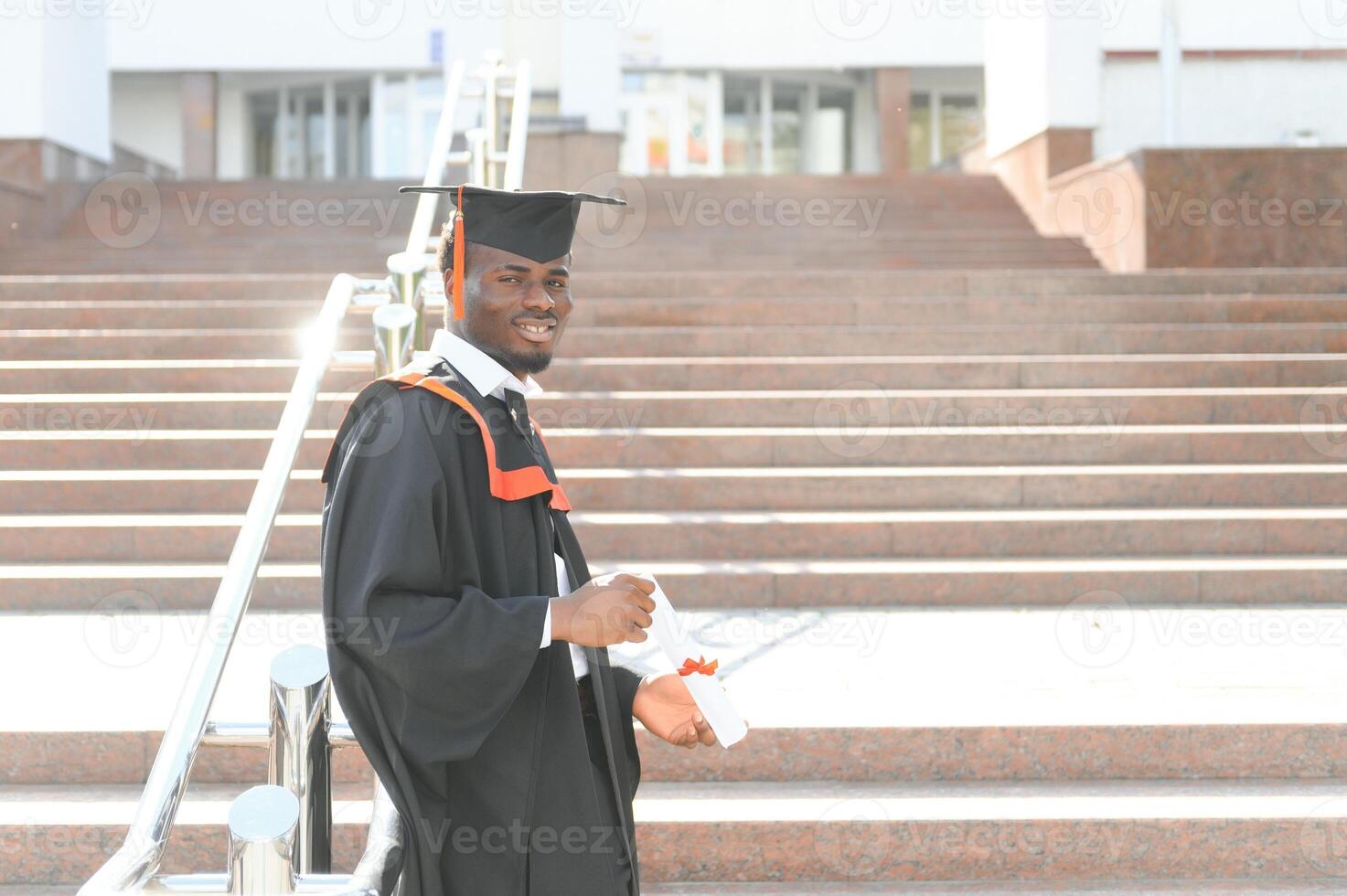 smiling african american graduated student showing diploma photo