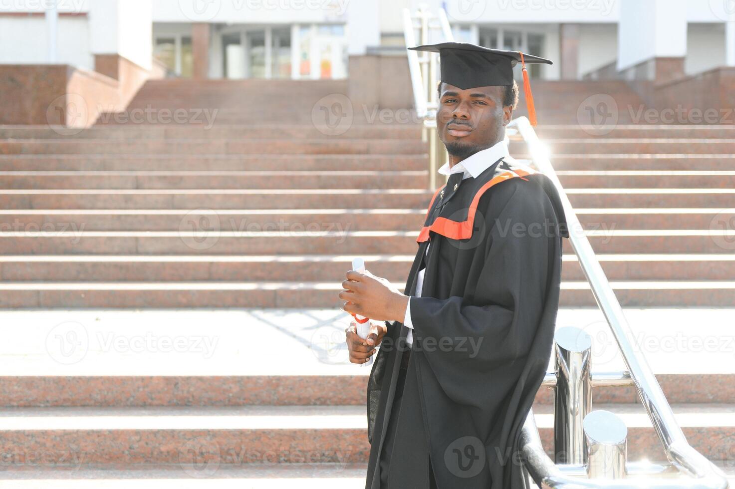smiling african american graduated student showing diploma photo