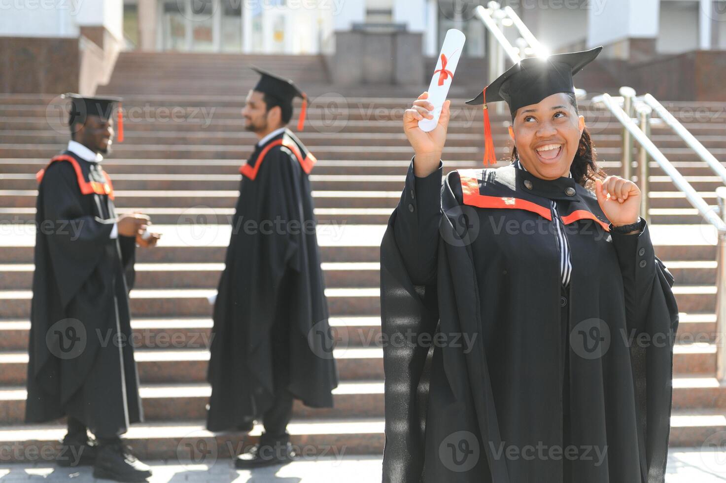 pretty african female college graduate at graduation with classmates photo