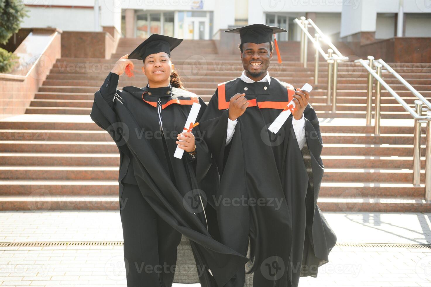 Happy african american couple students in graduation dresses photo