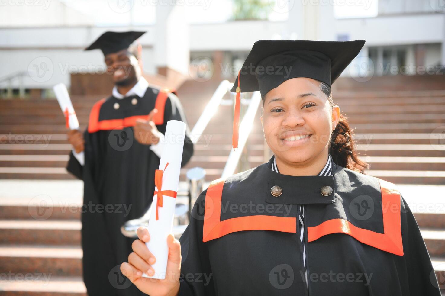 pretty african female college graduate at graduation with classmates photo