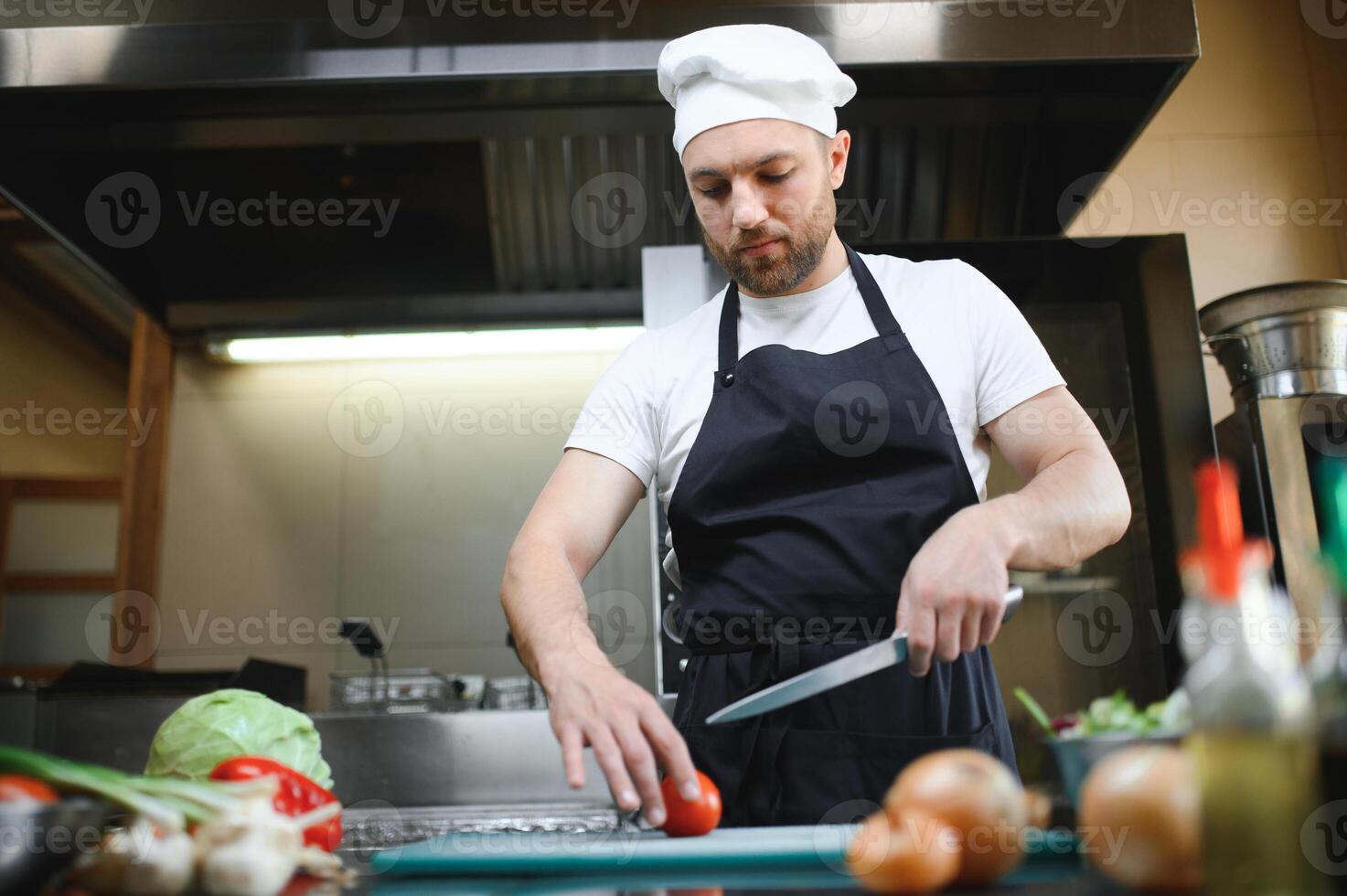 Chef cook in uniform cooking in the big cooker at the restaurant kitchen photo