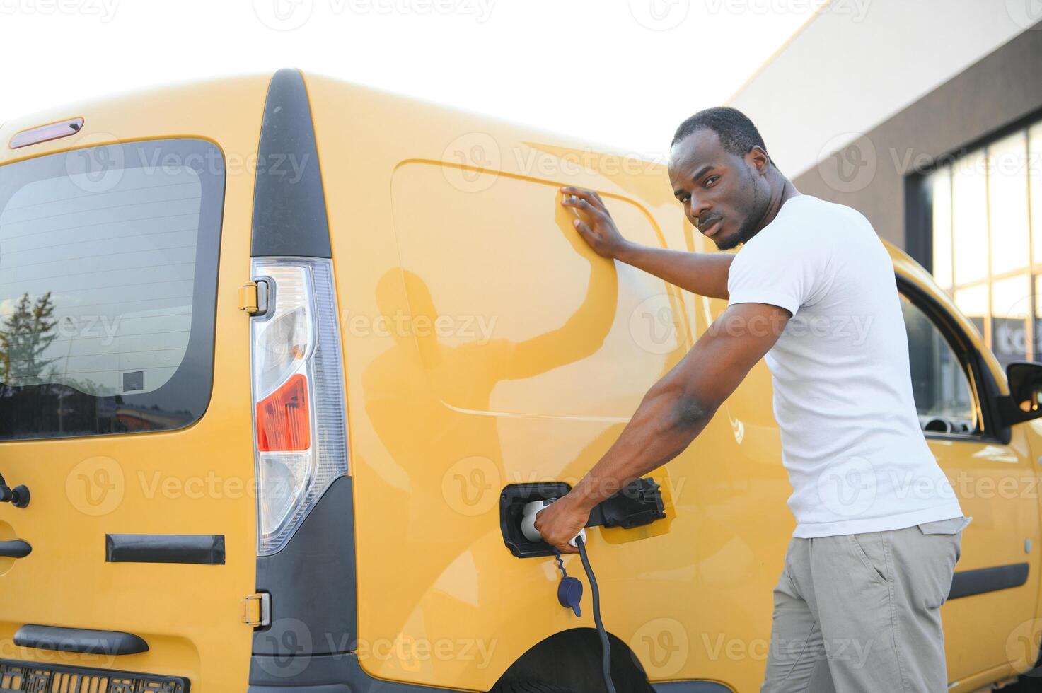 African American man charging his electric car. photo