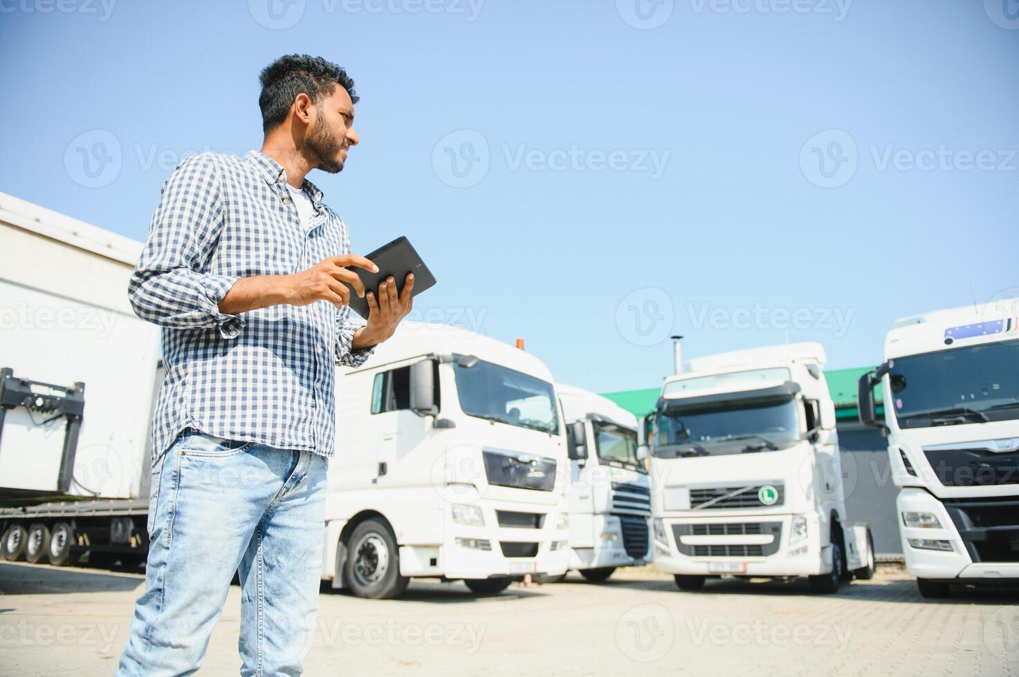 Young indian man standing by his truck. The concept of freight transportation. photo
