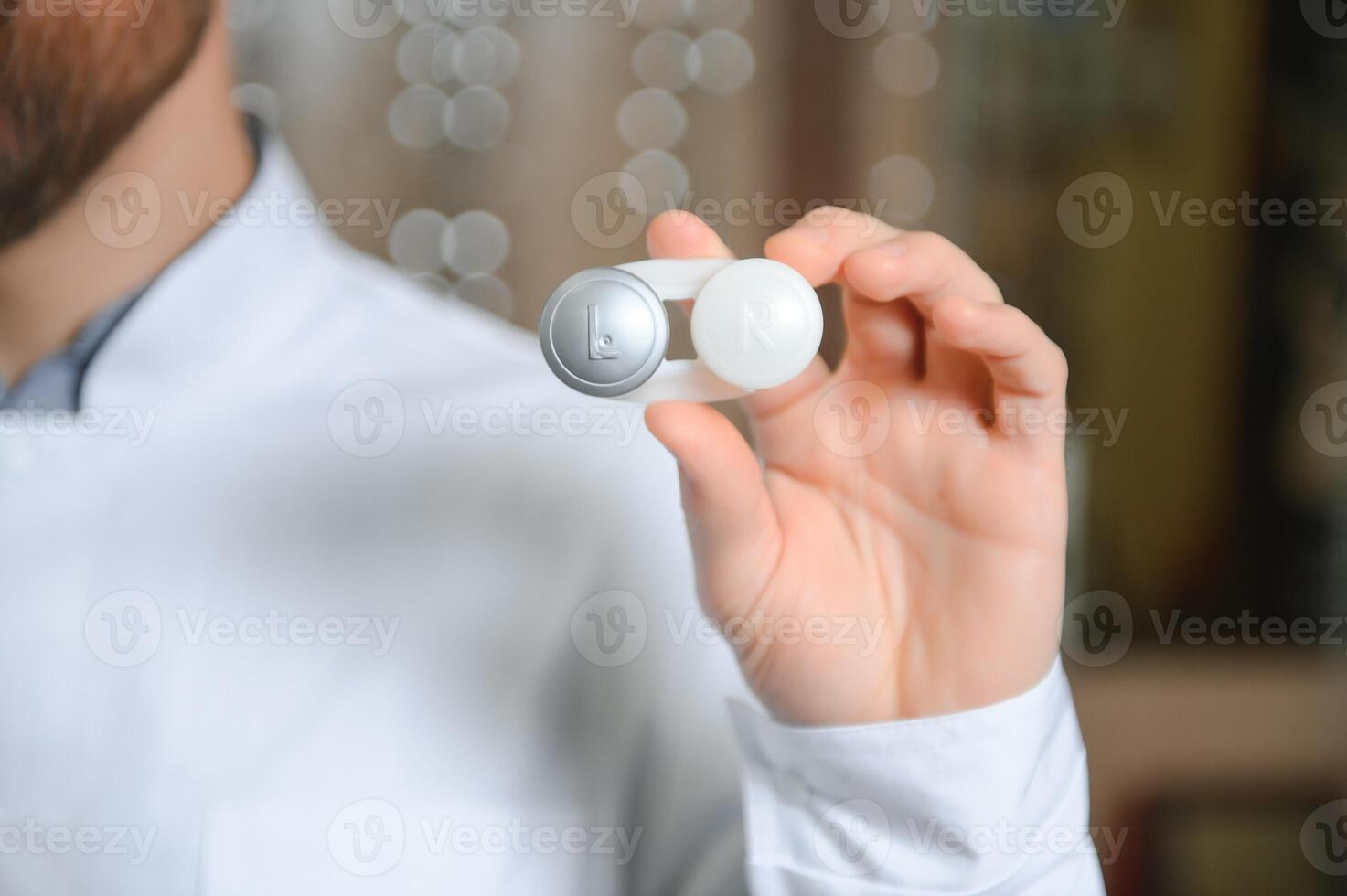 Male doctor hands giving pair of contact lens in case to patient offering choice isolated. Eyesight correction. Ophthalmology, excellent vision or optician shop concept. Laser surgery alternative photo