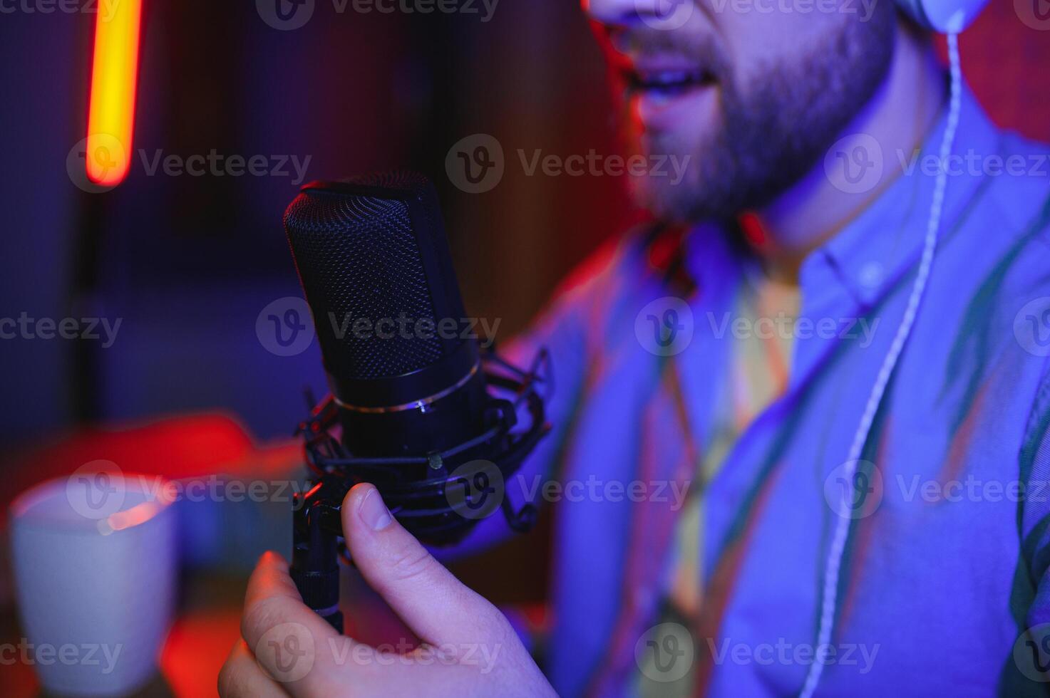 A blogger records content in his studio. The host of the blog is a young man who is very enthusiastic about telling his subscribers a story. photo