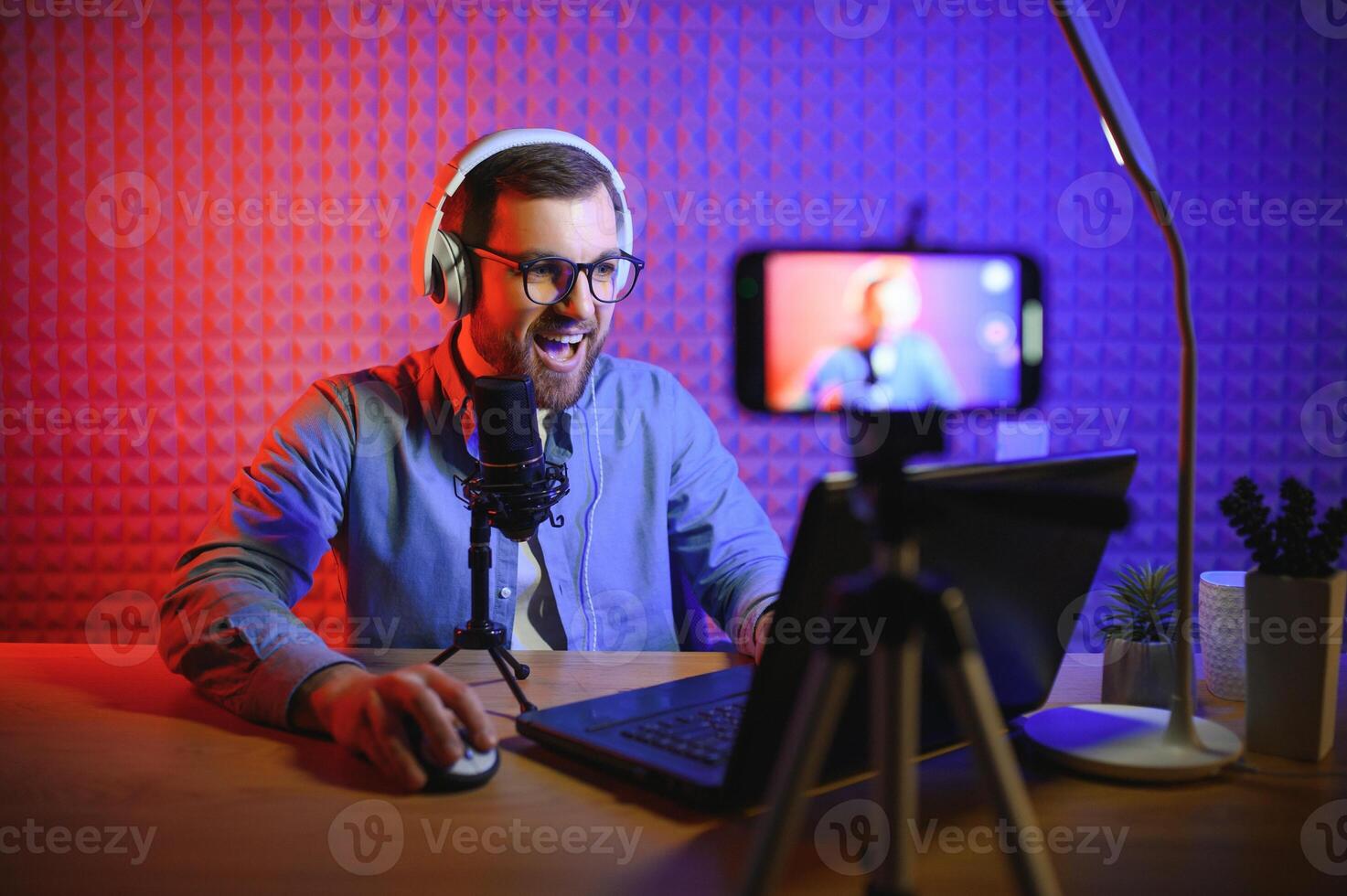 A blogger records content in his studio. The host of the blog is a young man who is very enthusiastic about telling his subscribers a story. photo