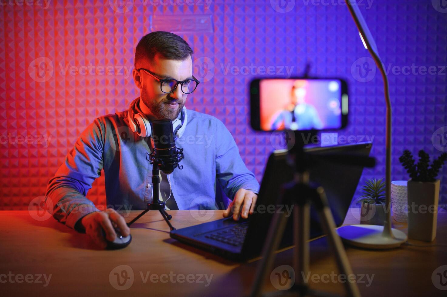 A blogger records content in his studio. The host of the blog is a young man who is very enthusiastic about telling his subscribers a story. photo