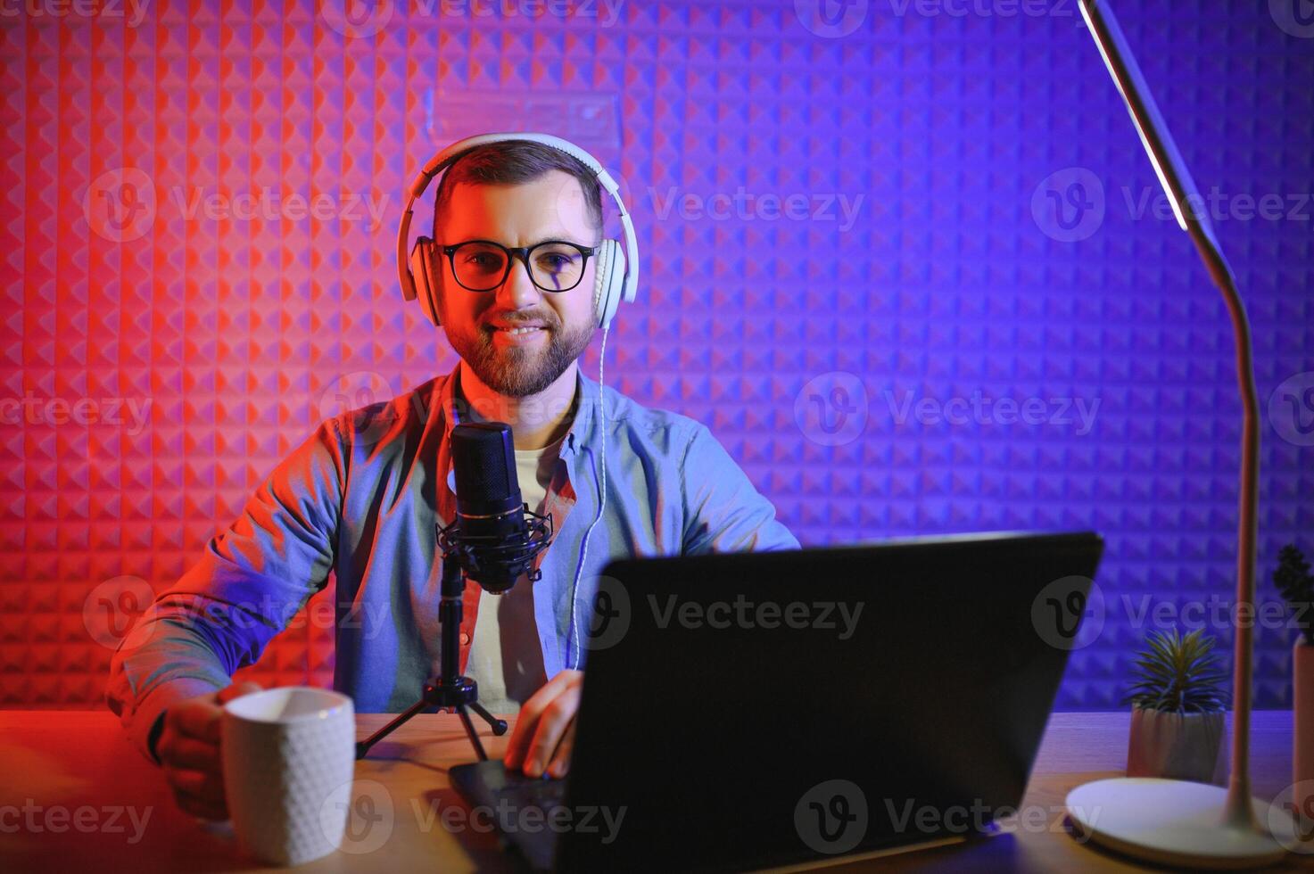 A blogger records content in his studio. The host of the blog is a young man who is very enthusiastic about telling his subscribers a story. photo