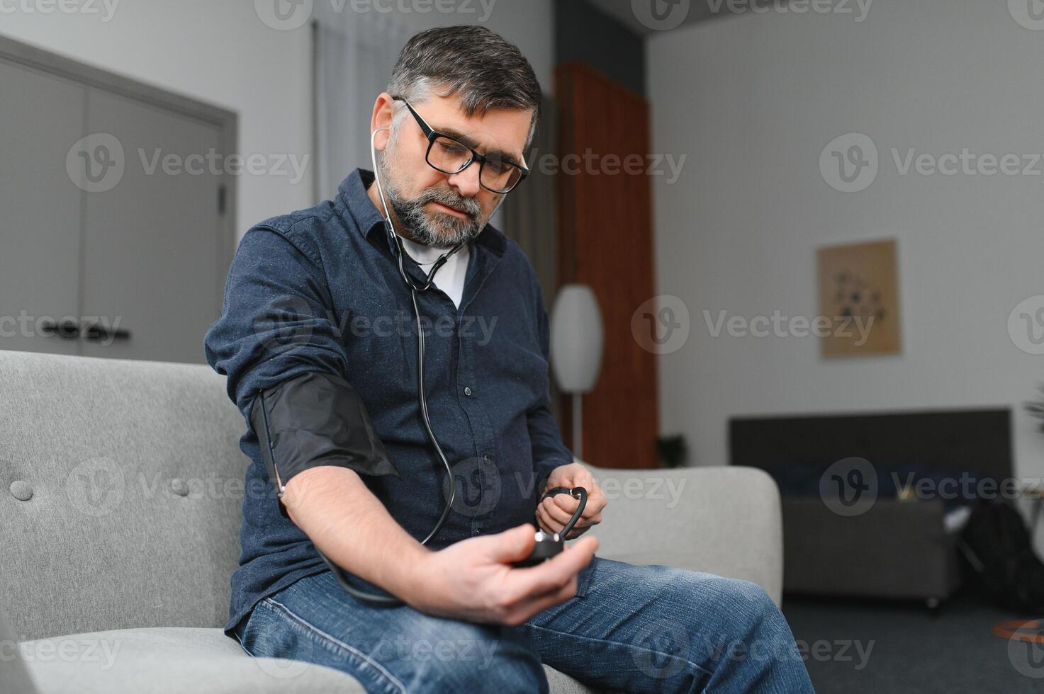 Senior man using medical device to measure blood pressure photo