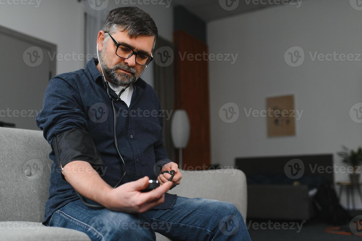 Senior man with hypertension having regular blood pressure control. photo