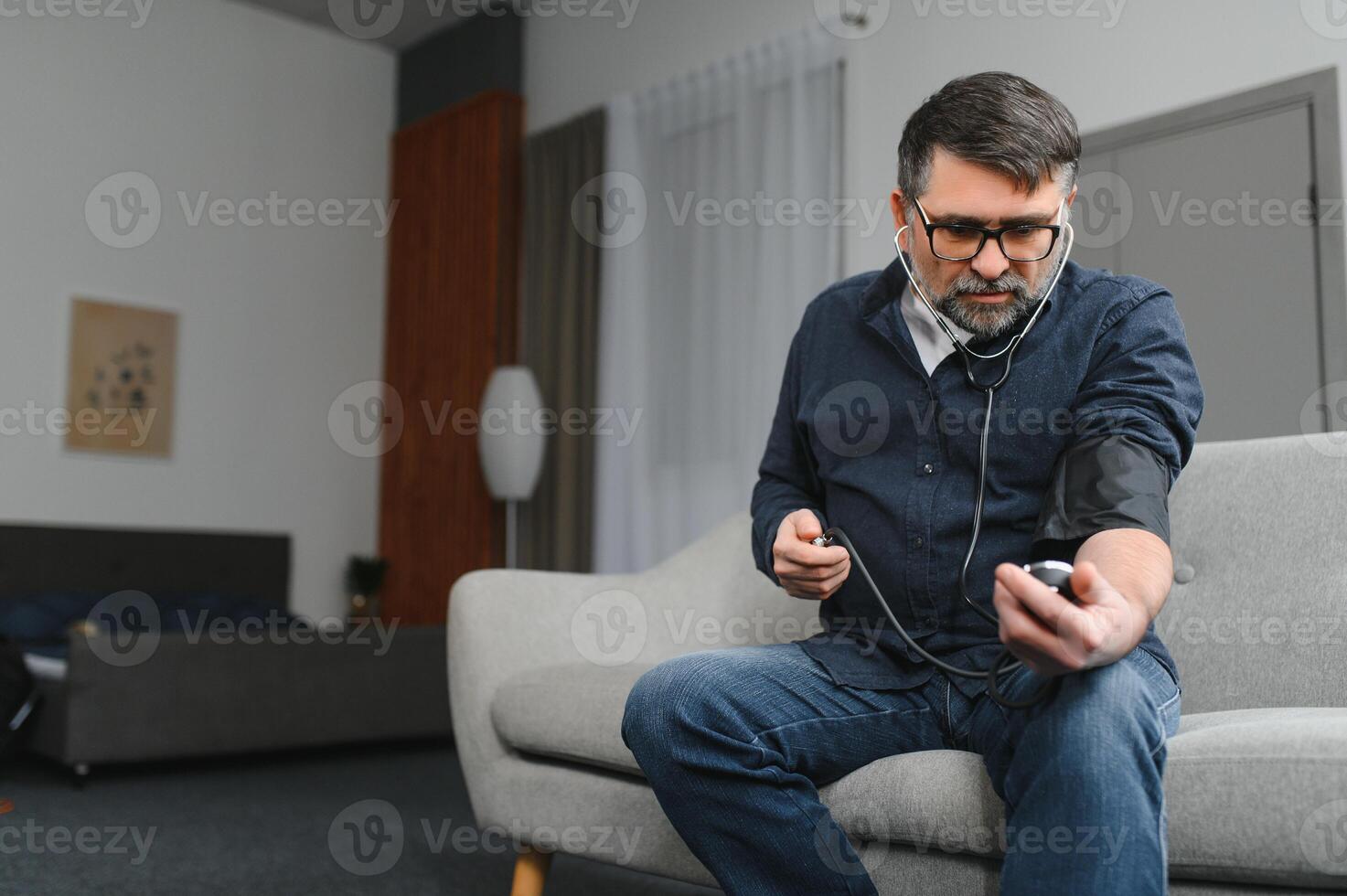 Senior man using medical device to measure blood pressure photo