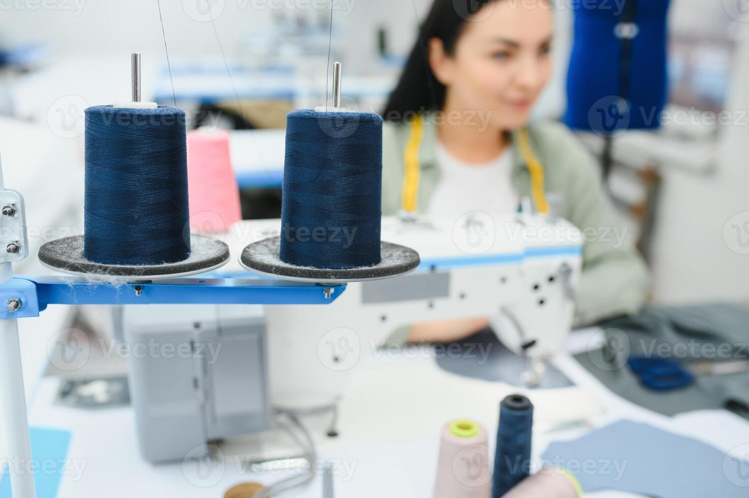 Beautiful young woman sewing clothes with sewing machine. photo