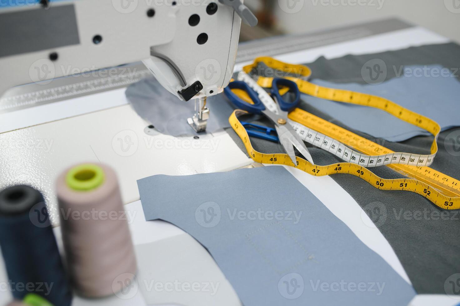 Composition of sewing thread, scissors and tape measure on a white table. Concept of a clothing designer photo