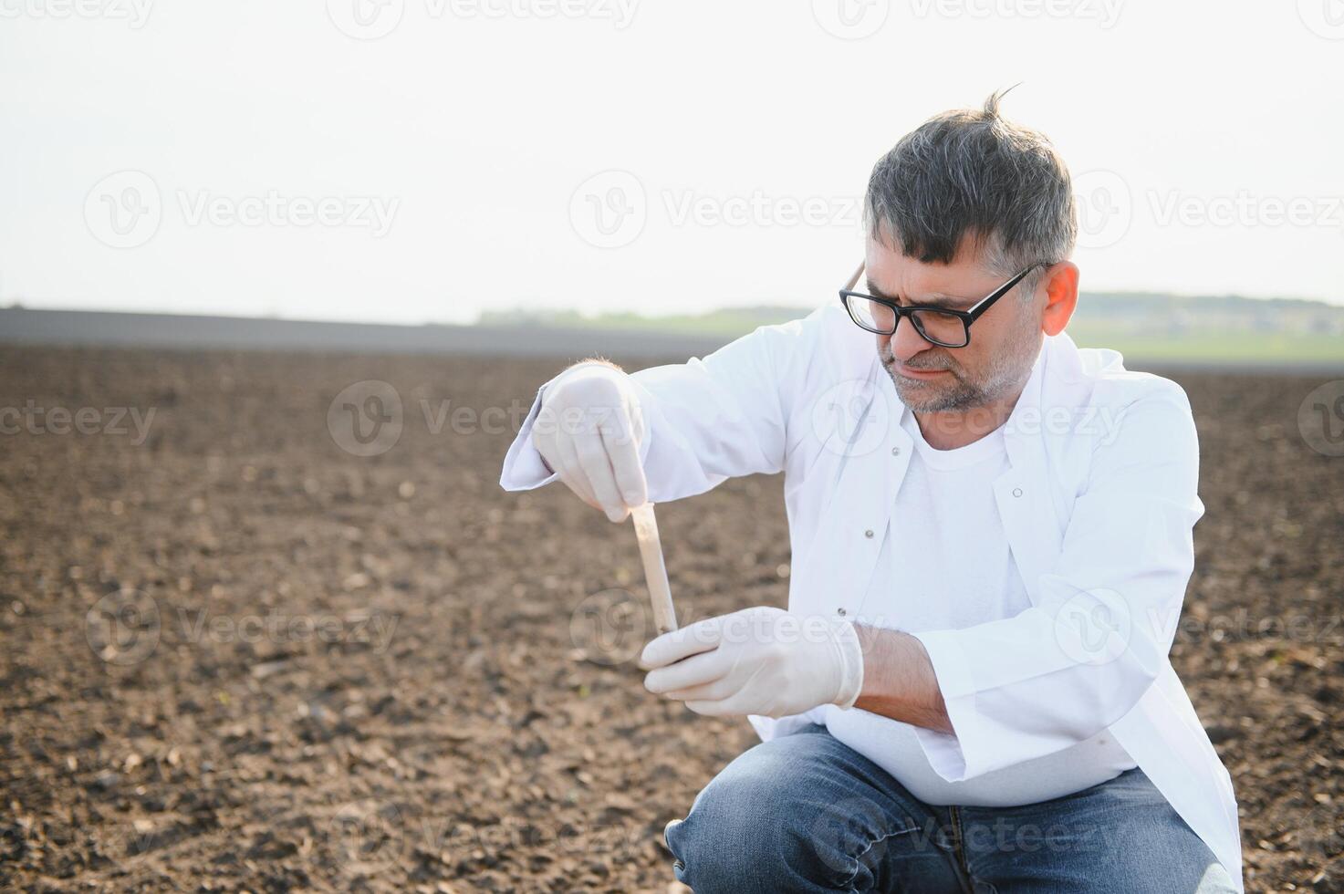 Soil Sampling. Agronomist taking sample with soil probe sampler. Environmental protection, organic soil certification, research photo
