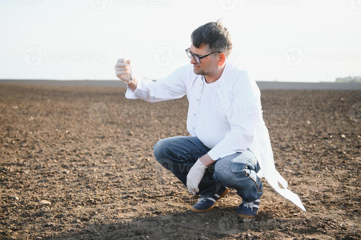 Soil Sampling. Agronomist taking sample with soil probe sampler. Environmental protection, organic soil certification, research photo