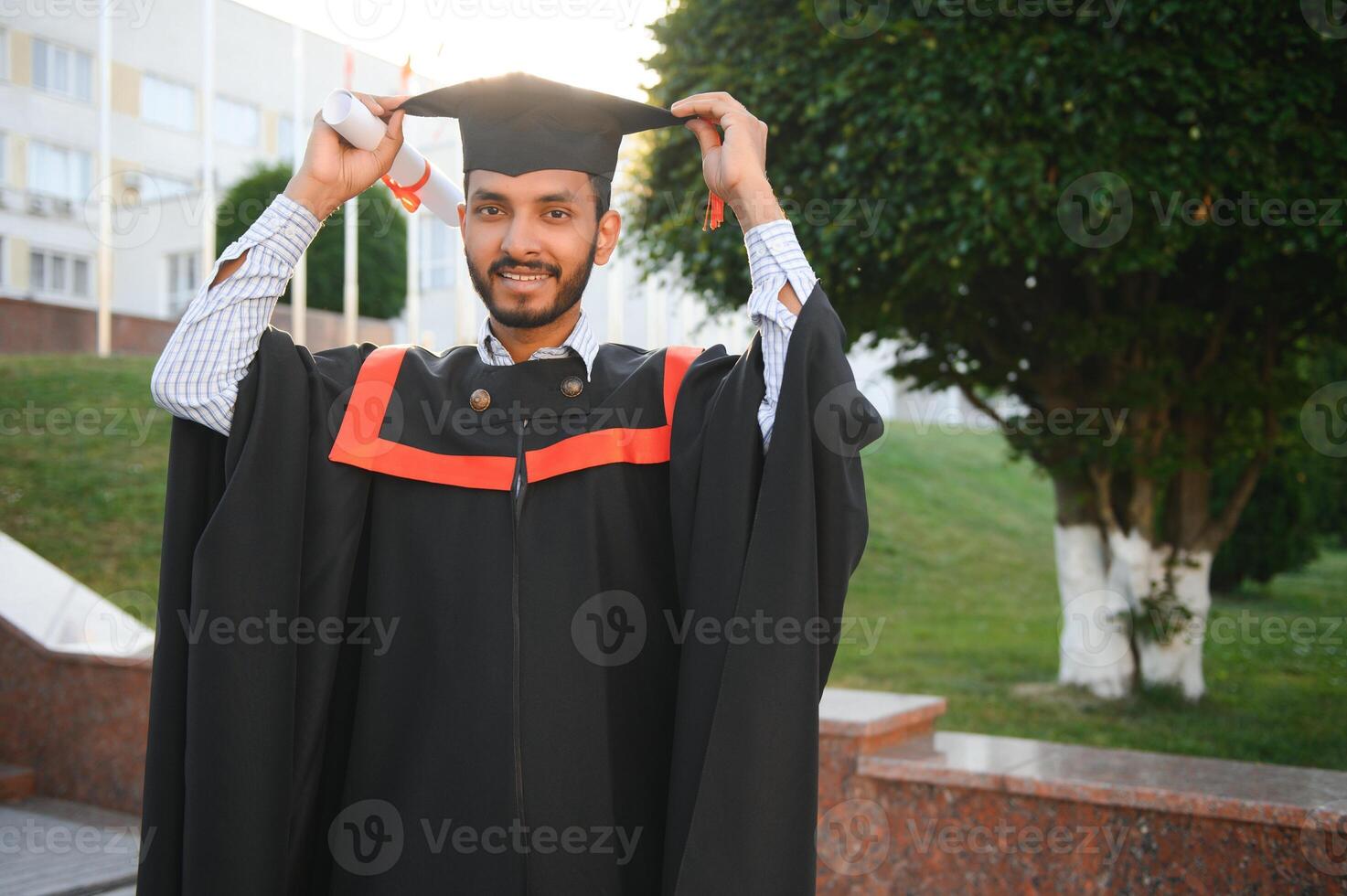 Handsome indian graduate in graduation glow with diploma. photo