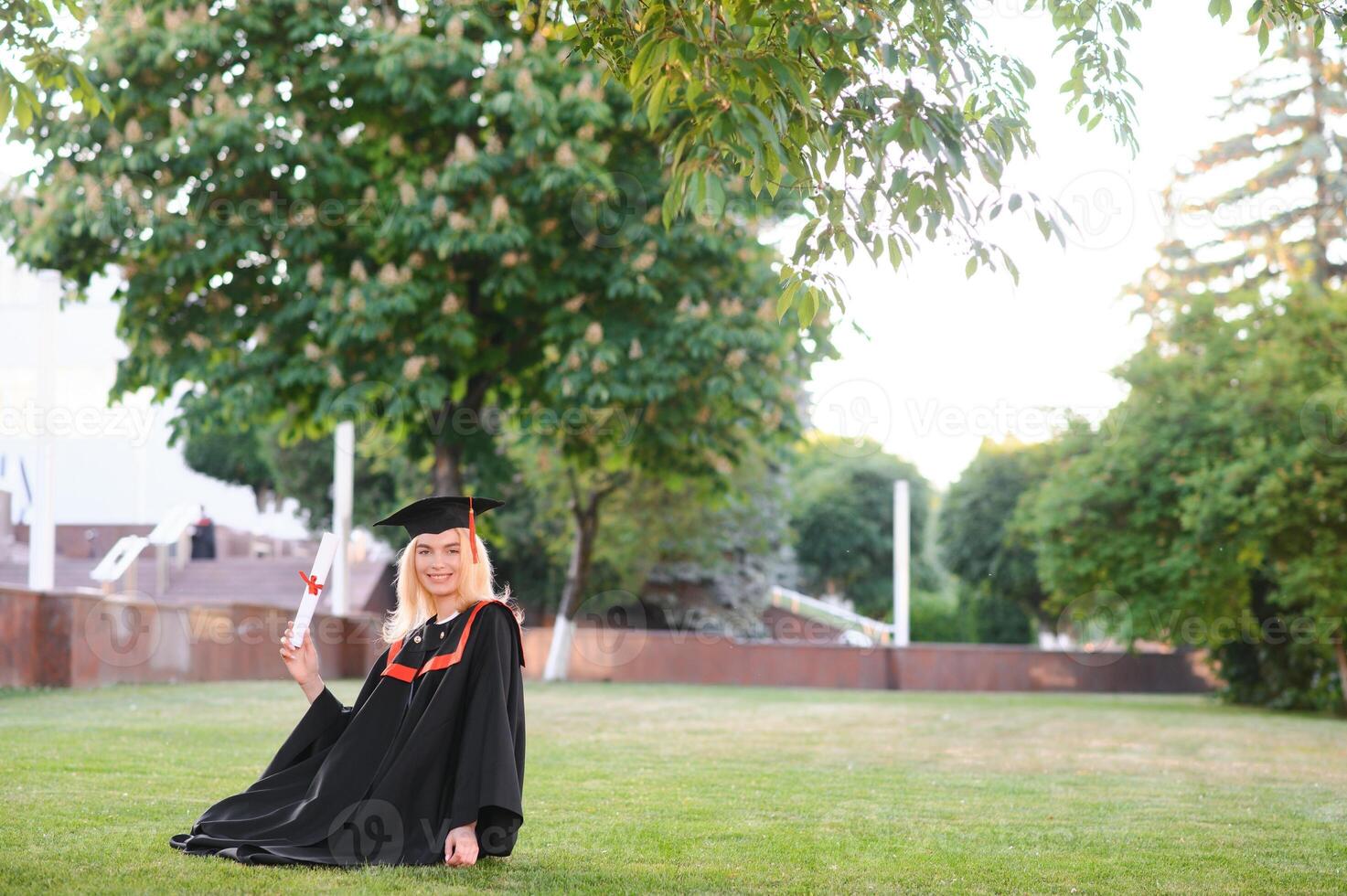 Happy graduation day for a young woman very beautiful with graduation cap smile large, while holding her diploma photo