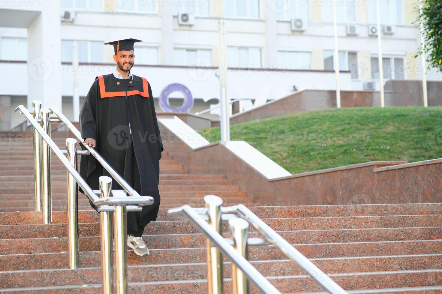 portrait of successful indian student in graduation gown. photo